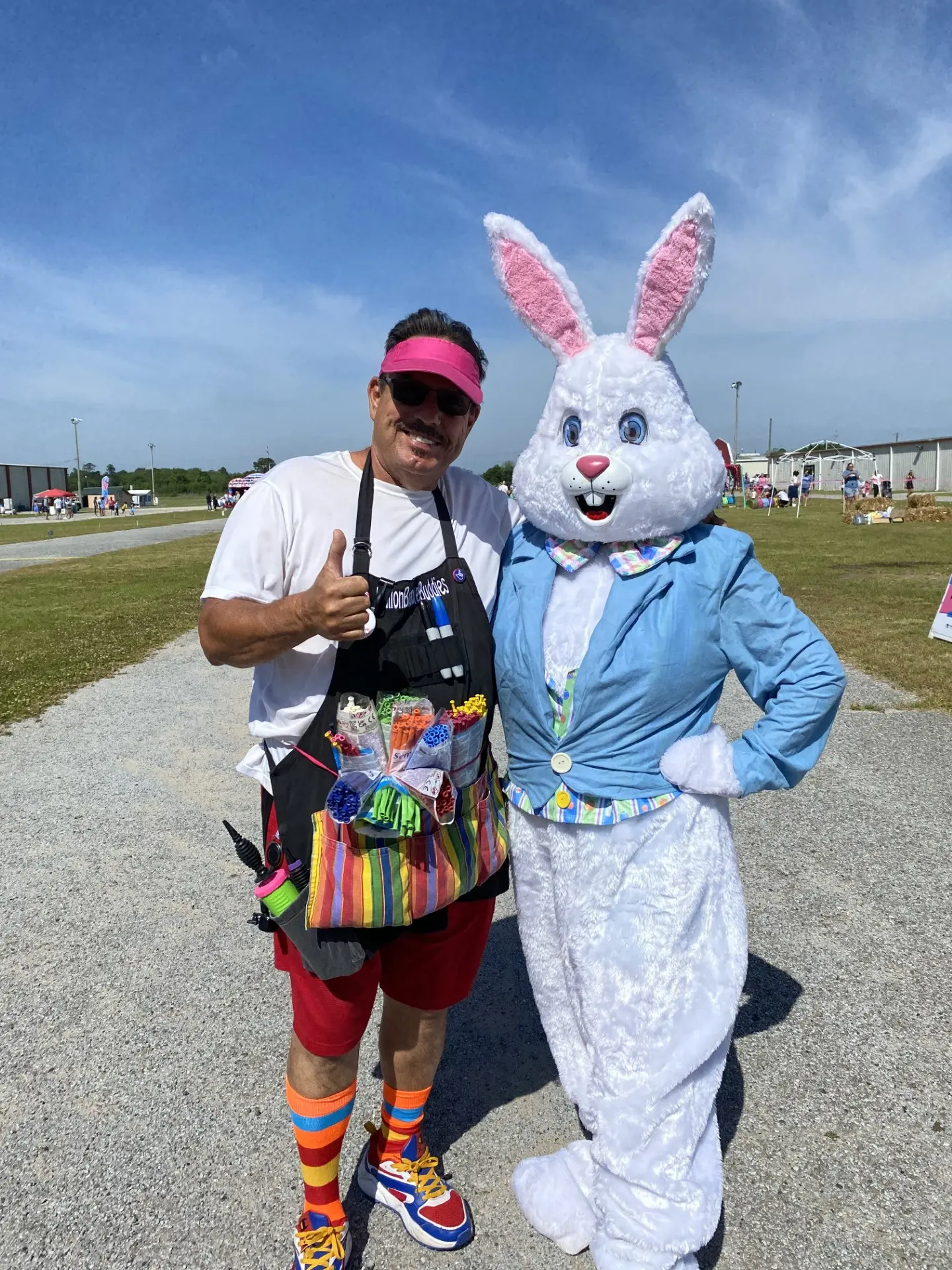 Man posing with a person in an Easter Bunny costume outdoors.