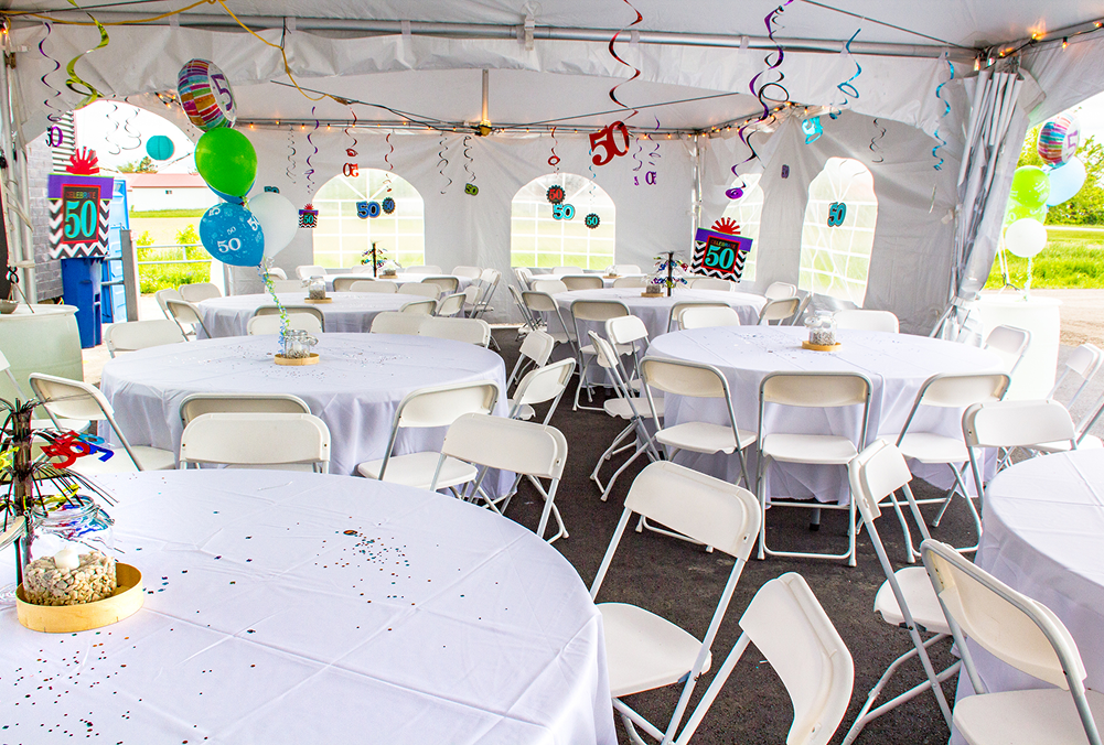 A decorated party tent with tables and chairs set up for guests.