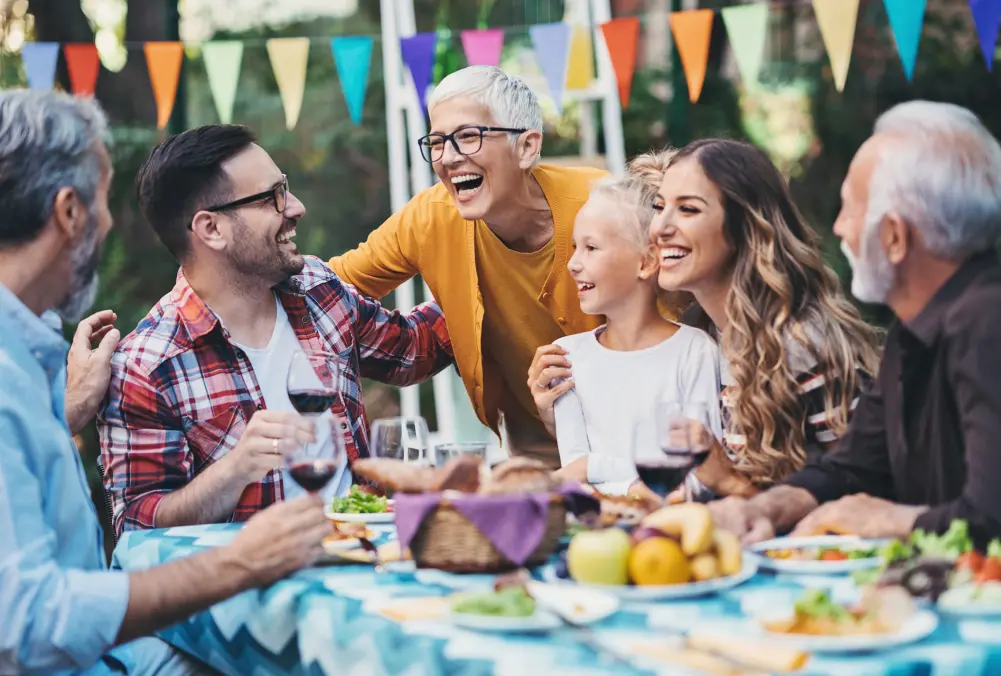 A joyful family enjoying a meal together outdoors.