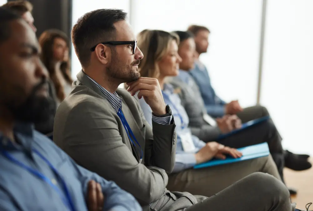 Business professionals attentively listening in a meeting.