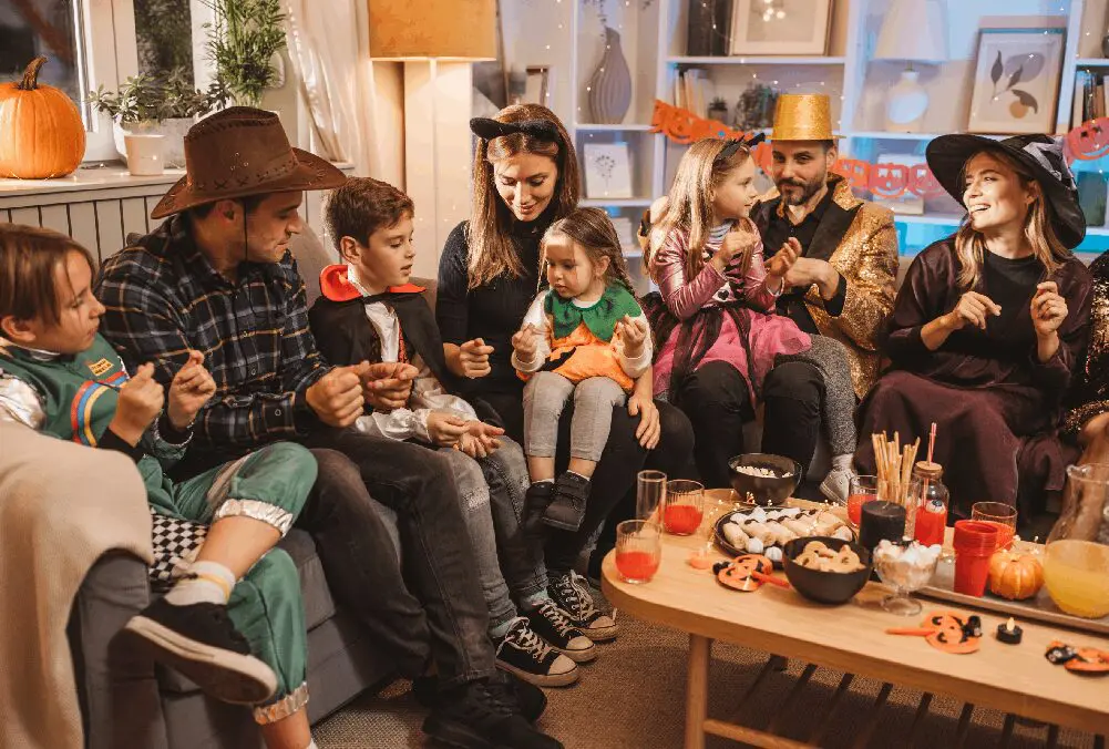 Family in Halloween costumes enjoying treats together.