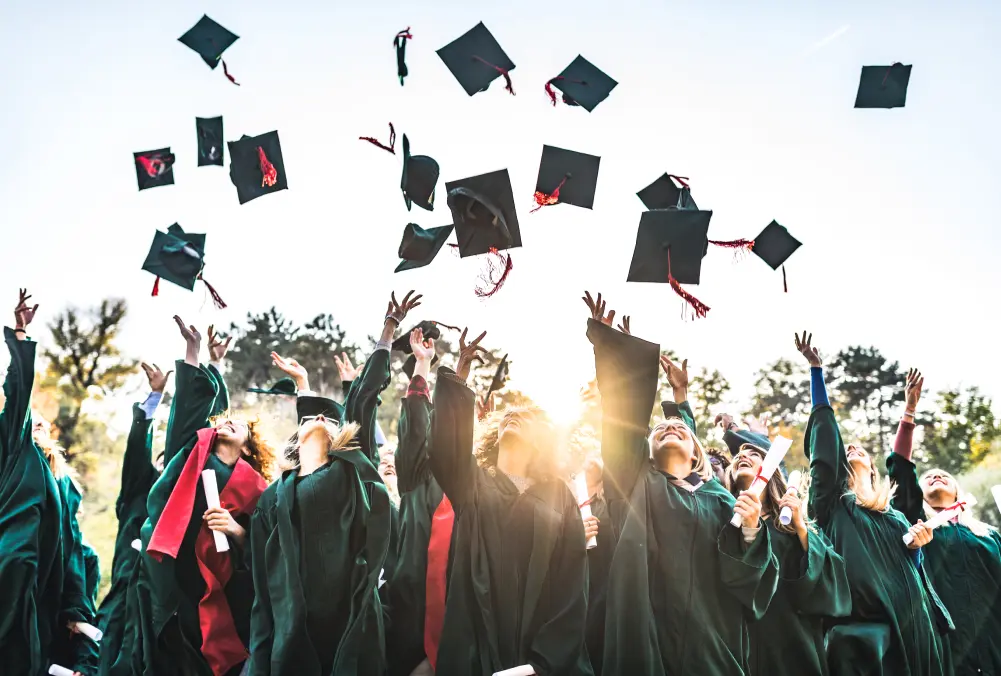 Graduates joyfully toss caps in the air during a celebration.